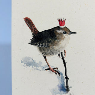 Aquarell-Illustration eines Zaunkönigs im Schnee mit Ast und Weihnachtskrone.